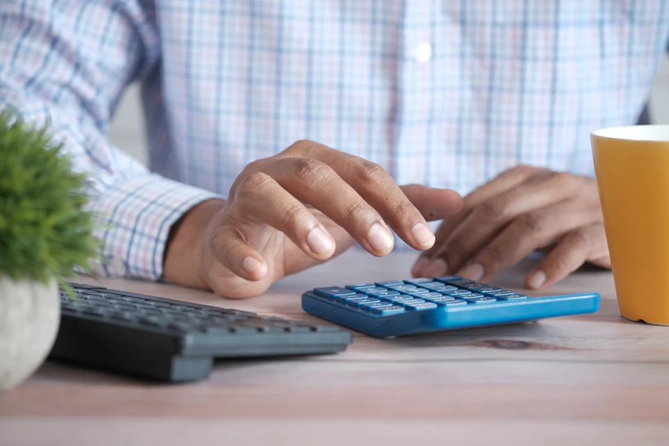 Mannanos cun una calculatora y furras riba la mesa